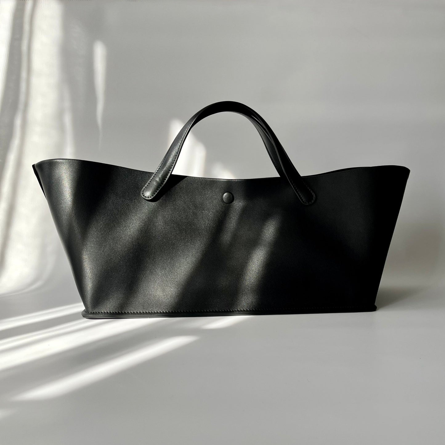 台形のようなユニークなフォルムと、大人のマルシェバッグのようなデザインが魅力のGrande bagのショルダーストラップなしVer.が登場。Grande bagよりやや大きめのしっかりとした作り、革の質感はマットで高級感があります。他とは違う個性的なバッグを探している方におすすめです。
